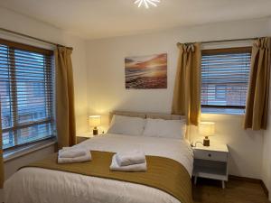 a bedroom with a bed with two towels on it at Vyn's Holiday home - Sleeps 6 in Cardiff