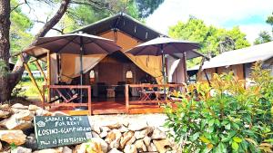 a safari tent with a sign in front of it at VELA Glamping - Camp Čikat - Lošinj in Mali Lošinj