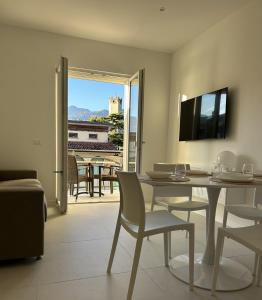 a dining room with a table and chairs and a television at Casa Nane in Malcesine