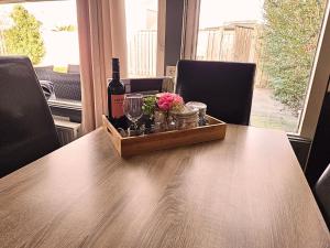 a wooden table with a bottle of wine and flowers at Zeeuwse Luwte in Stavenisse