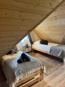 two beds in a room with wooden ceilings at Apartamenty nad Przełomem Białki Apartments in a nature reserve Przełom Białki in Nowa Biała
