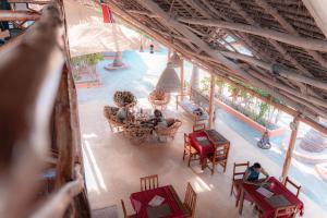 an overhead view of a pool with people sitting at tables at Sunset Mkuu Boutique Hotel in Michamvi