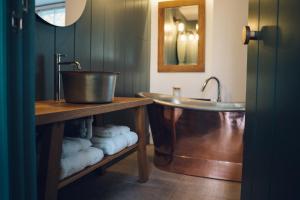 a bathroom with a tub and a sink and towels at Nant Gwrtheyrn in Llithfaen