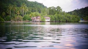 a house in the middle of a body of water at War Homestay in Pulau Minyaifuin