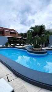 a large blue swimming pool with palm trees in the background at Hotel Termal Rio Hondo in Termas de Río Hondo