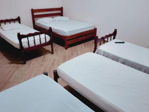 a group of four beds in a room at pousada benção in Aparecida