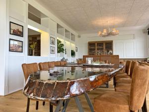 a dining room with a glass table and chairs at Hotel Fresena in Baltrum