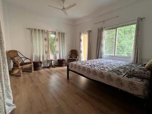 a bedroom with a bed and a large window at Pappu in Siliguri