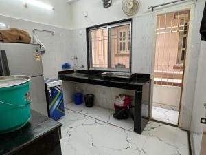 a kitchen with a table and a refrigerator at Pappu in Siliguri