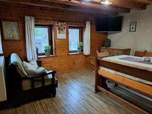 a living room with a bed and a tv and windows at River Garden in Beli Osŭm