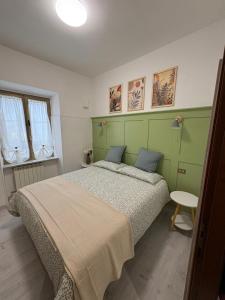 a bedroom with a large bed with a green headboard at Nella Rosa in Monterotondo