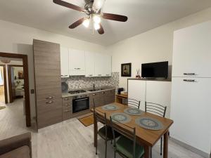 a kitchen with a table and a ceiling fan at Nella Rosa in Monterotondo