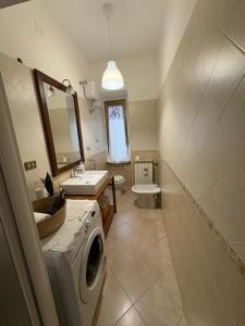 a bathroom with a sink and a washing machine at Nella Rosa in Monterotondo