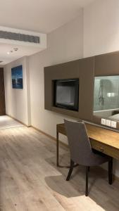 a room with a desk and a television and a chair at Padorama in Nha Trang
