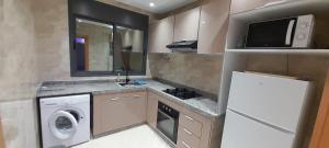 a small kitchen with a washer and dryer at Maghrib ARABI OULED OUJIH in Kenitra