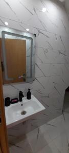 a white bathroom with a sink and a mirror at Maghrib ARABI OULED OUJIH in Kenitra +10 photos
