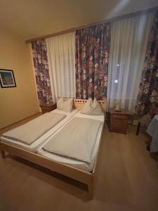 a bedroom with two beds and a window with curtains at Gasthof Vogelleitner in Sankt Aegyd am Neuwalde