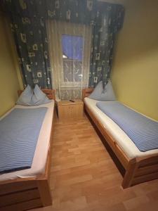 two beds in a room with a window at Gasthof Vogelleitner in Sankt Aegyd am Neuwalde