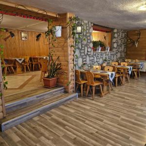 a restaurant with wooden floors and tables and chairs at Pod Tatrami widok na Tatry, sauna, parking, blisko Term Bukovina in Bukowina Tatrzańska