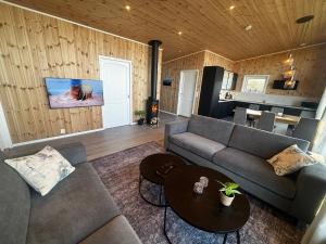 a living room with a couch and a table at Unik og moderne hytte med utsikt mot havet 38 Otterlei Resort in Haram