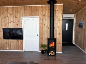 a fireplace in a room with wooden walls at Unik og moderne hytte med utsikt mot havet 38 Otterlei Resort in Haram +46 photos