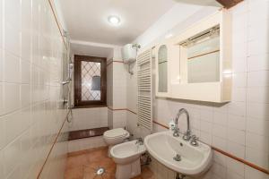 a white bathroom with a toilet and a sink at La Casetta al Corso in Montefiascone +15 photos
