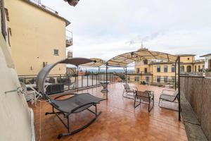 a balcony with chairs and umbrellas on a patio at La Casetta al Corso in Montefiascone