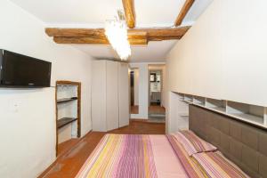 a living room with a tv and a rug at La Casetta al Corso in Montefiascone