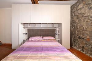 a bed in a room with white cabinets at La Casetta al Corso in Montefiascone