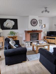 a living room with two couches and a fireplace at Cottage in Auvergne in Laval-sur-Doulon