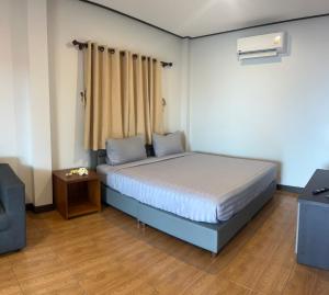 a small bedroom with a bed and a chair at Pimmada Hut in Haad Pleayleam