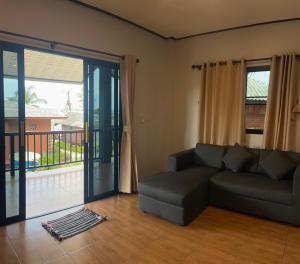 a living room with a couch and a sliding glass door at Pimmada Hut in Haad Pleayleam +210 photos