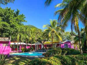 a resort with a swimming pool and palm trees at Rancho Colibrí in Acajutla