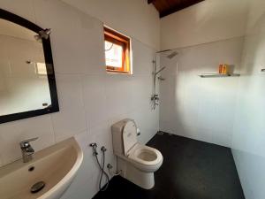 a bathroom with a white toilet and a sink at Sonic Villa,Beruwala in Beruwala