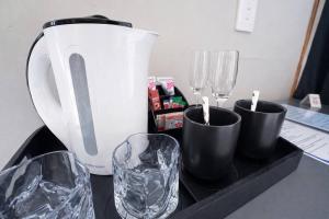 a counter with three glasses and a blender on it at Elite Luxe Cabin Suite in Welkom