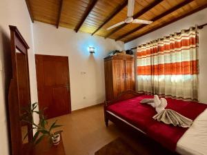 a bedroom with a red bed and a window at Sonic Villa,Beruwala in Beruwala