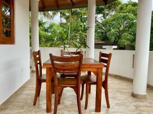 a wooden table and chairs on a porch at Sonic Villa,Beruwala in Beruwala