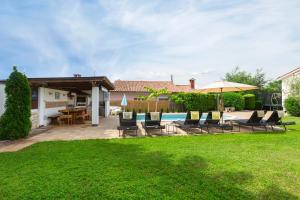 a backyard with chairs and a swimming pool at Villa Luka Nedešćina in Nedeščina