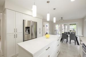 a kitchen with white cabinets and a dining room at Windsor Luxury Oasis in Windsor