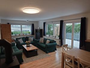 a living room with a green couch and a table at Ferienwohnung Dons in Grömitz