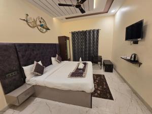 a hotel room with a bed and a television at prabh aasra in Ayodhya
