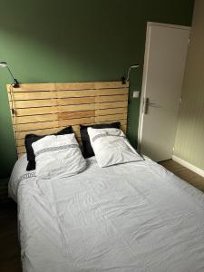 a bed with white sheets and pillows in a bedroom at La Petite Maison in Brest