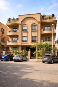 a building with three cars parked in front of it at The New Cairo 3BR Residence in Cairo