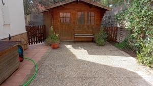 a backyard with a wooden shed with a green hose at Villa Sol in Roquetas de Mar