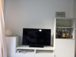 TV de pantalla plana en un centro de entretenimiento blanco en Apartamento Portosín, en Portosín