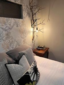 a bedroom with a bed and a table with a flowery wallpaper at Otista Self-Catering Cottage Bloemfontein in Bloemfontein