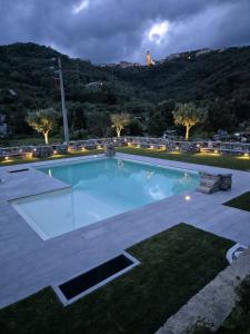 a swimming pool at night with a mountain in the background at Il Nuovo Vecchio Frantoio di Gardan Con Piscina in Vignana