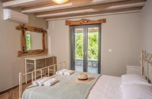a bedroom with a bed with a hat on it at Villa Dias by Elayan Villas Corfu in Karousádes +29 photos