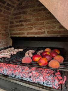 a grill with meat and apples and other food on it at Passo del Mattino in Locati