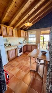 a kitchen with a wooden table and a tableasteryasteryasteryasteryasteryasteryastery at Casa de Santana in Santana